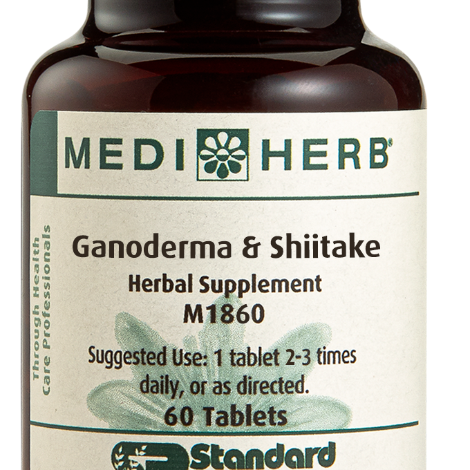 A bottle of Ganoderma & Shiitake herbal supplement next to a tablet.